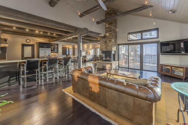 living room with dark wood-type flooring, high vaulted ceiling, a stone fireplace, beamed ceiling, and wood ceiling