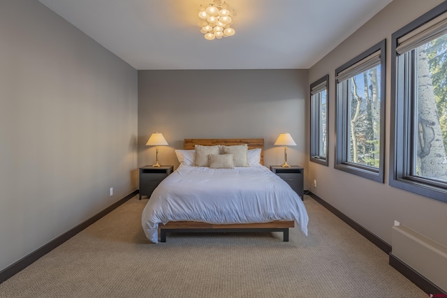 carpeted bedroom featuring a chandelier