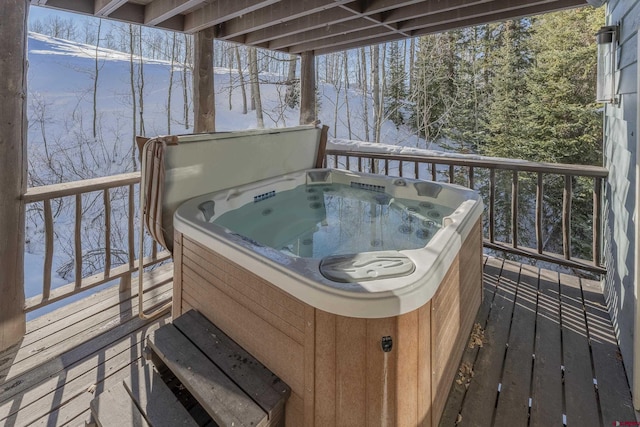 snow covered deck with a hot tub