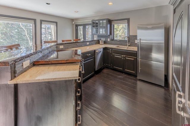 kitchen featuring appliances with stainless steel finishes, backsplash, dark hardwood / wood-style floors, and sink