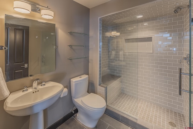 bathroom with tile patterned flooring, toilet, a shower with door, and sink