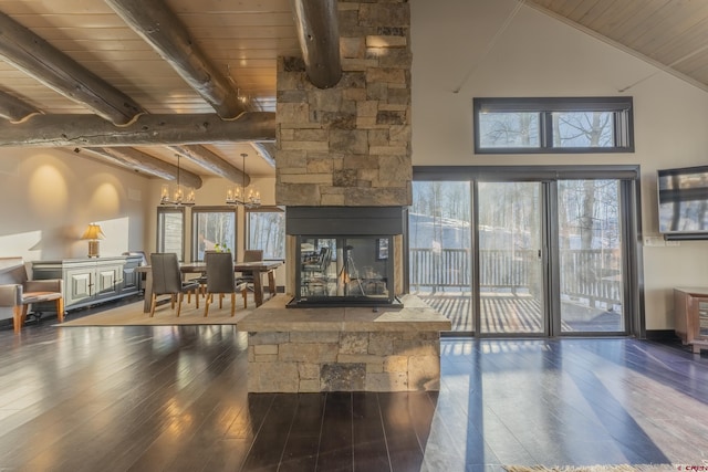 interior space featuring beamed ceiling, dark wood-type flooring, a stone fireplace, and wooden ceiling