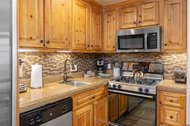 kitchen with tasteful backsplash, light stone countertops, sink, and appliances with stainless steel finishes