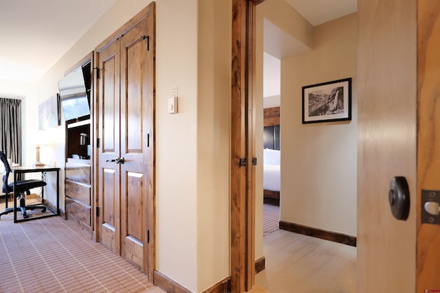 hallway with light hardwood / wood-style floors