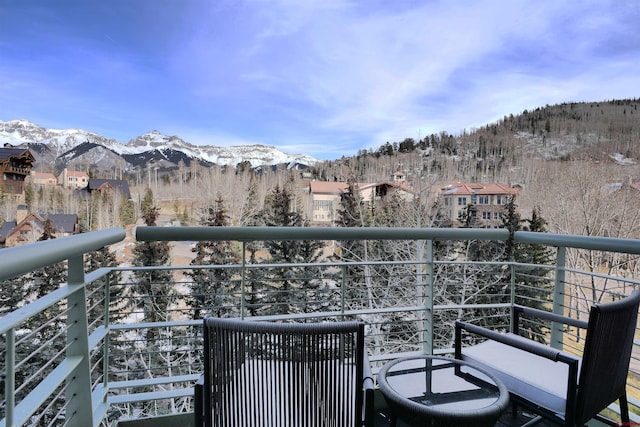 snow covered back of property featuring a mountain view