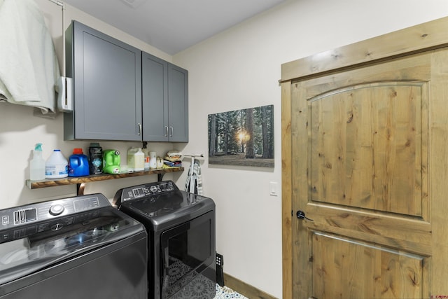 clothes washing area with cabinets and washer and dryer