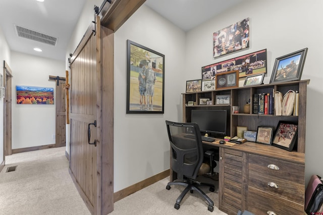 office with a barn door and light colored carpet