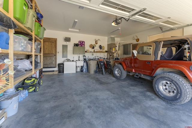 garage featuring a garage door opener, sink, and electric panel