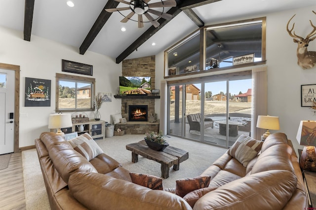 carpeted living room featuring beamed ceiling, ceiling fan, a fireplace, and high vaulted ceiling