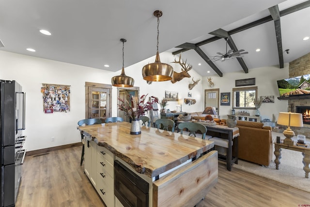 kitchen with lofted ceiling with beams, a kitchen island, wood counters, and built in microwave