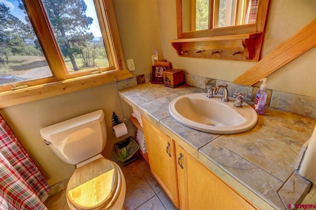 bathroom featuring vanity, toilet, and tile patterned flooring