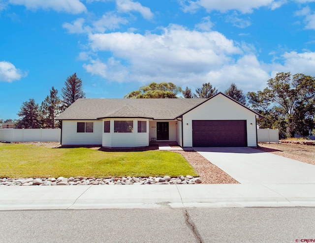 ranch-style house with a garage and a front lawn