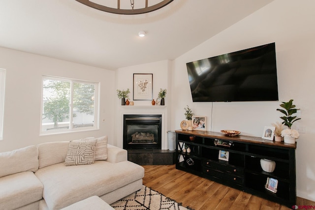 living room with a fireplace, hardwood / wood-style flooring, and vaulted ceiling