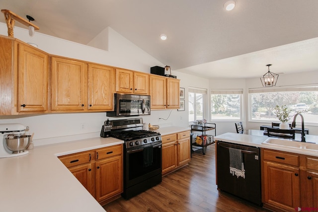 kitchen featuring pendant lighting, black gas range, lofted ceiling, sink, and dishwashing machine