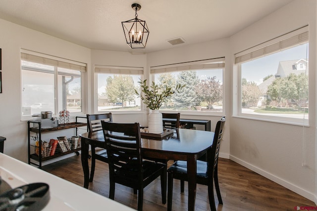 dining room featuring dark hardwood / wood-style floors, a wealth of natural light, and an inviting chandelier