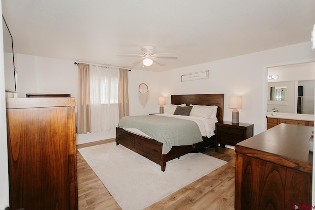 bedroom with light hardwood / wood-style floors, ensuite bath, and ceiling fan