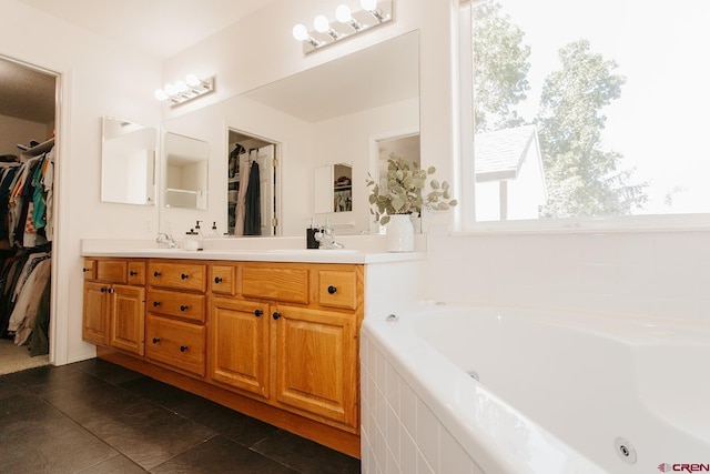 bathroom with tiled bath, tile patterned flooring, and vanity