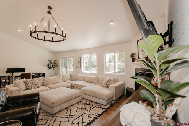 living room featuring a chandelier, hardwood / wood-style floors, and vaulted ceiling