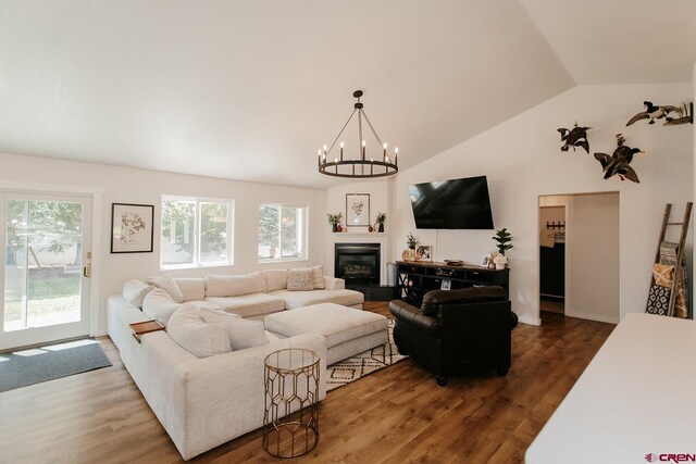 living room with hardwood / wood-style floors, a notable chandelier, and plenty of natural light