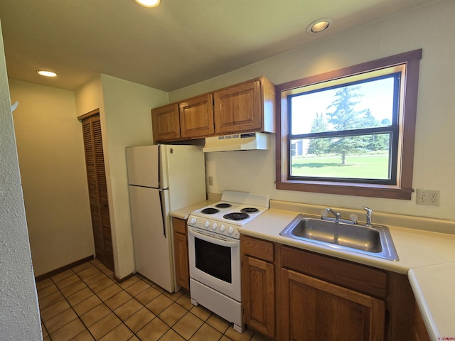 kitchen with light tile patterned flooring, white appliances, and sink