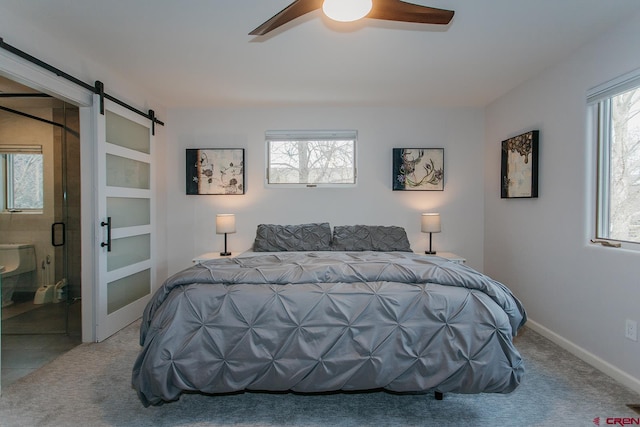 bedroom featuring light carpet, a barn door, multiple windows, and ceiling fan