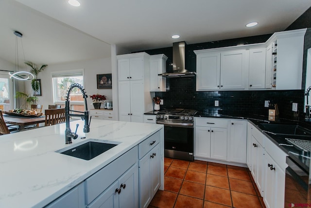 kitchen featuring backsplash, wall chimney exhaust hood, sink, and stainless steel range