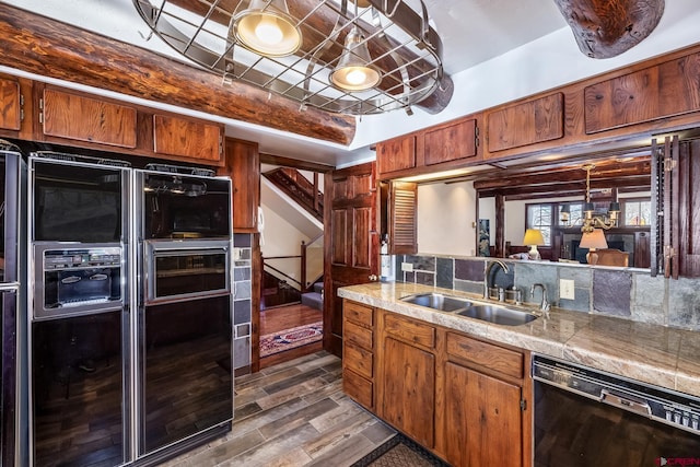 kitchen featuring sink, tasteful backsplash, dark wood-type flooring, and black appliances