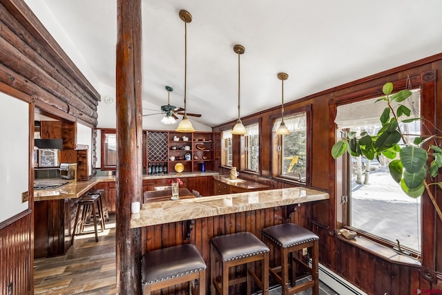 bar featuring pendant lighting, wood walls, lofted ceiling, ceiling fan, and baseboard heating