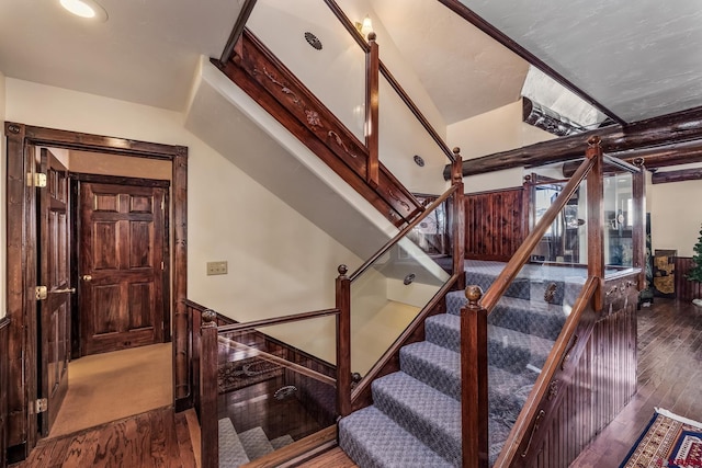 staircase with wood walls and wood-type flooring