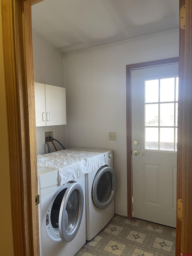 clothes washing area with cabinets and independent washer and dryer