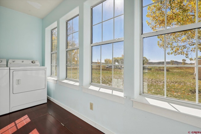 washroom featuring plenty of natural light, dark hardwood / wood-style floors, and washing machine and clothes dryer