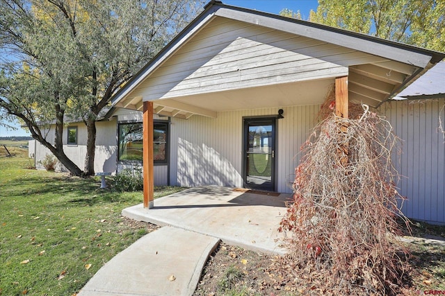 entrance to property with a lawn