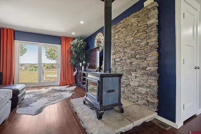 living room with a wood stove and dark hardwood / wood-style flooring