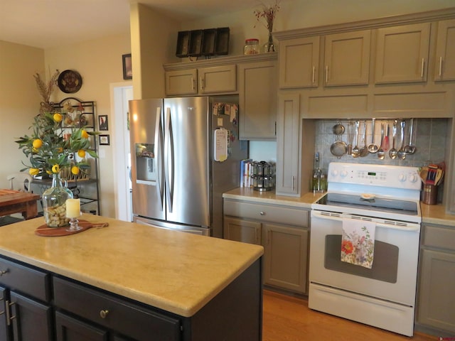 kitchen with gray cabinetry, a center island, light hardwood / wood-style flooring, white range with electric stovetop, and stainless steel fridge