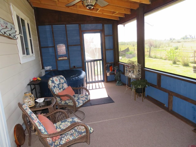 sunroom with lofted ceiling with beams and ceiling fan