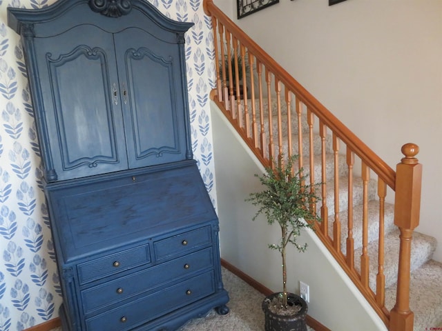 stairway featuring carpet flooring