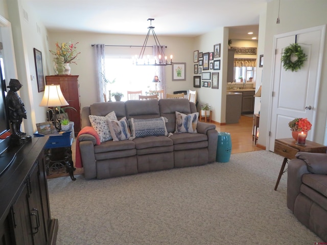 living room featuring light carpet and an inviting chandelier