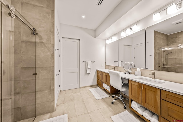 bathroom with tile patterned floors, vanity, and walk in shower