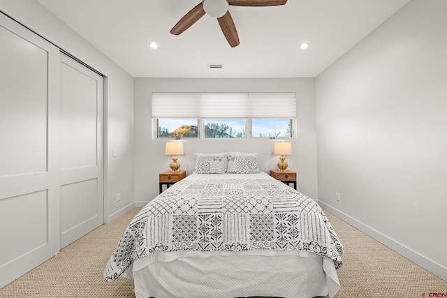 carpeted bedroom with ceiling fan and a closet