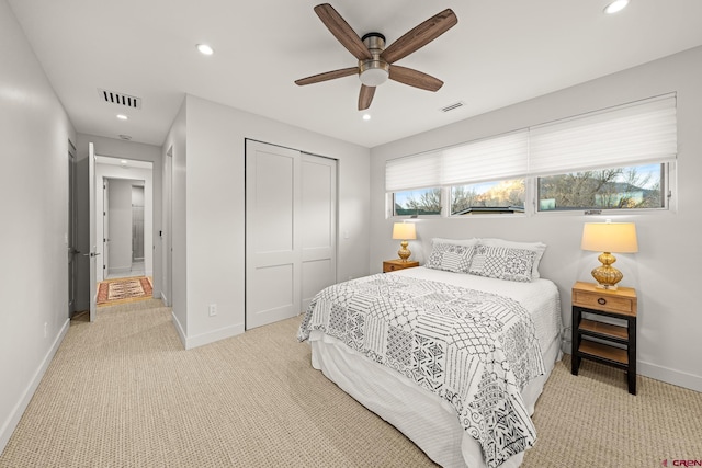 carpeted bedroom with ceiling fan and a closet