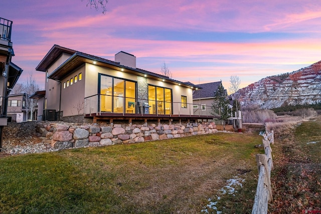 back house at dusk featuring a yard