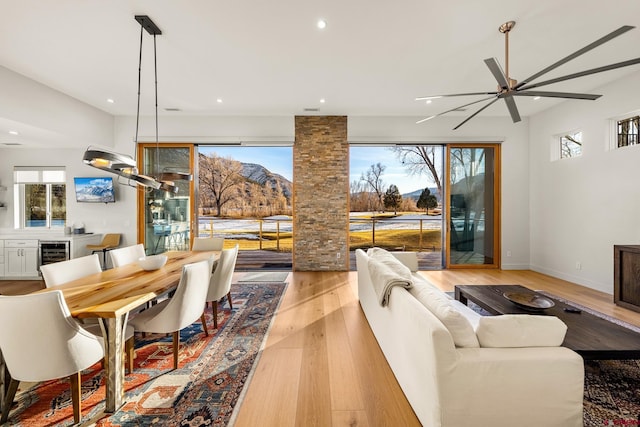 living room with ceiling fan, light wood-type flooring, and wine cooler