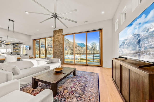 living room featuring ceiling fan and light hardwood / wood-style flooring