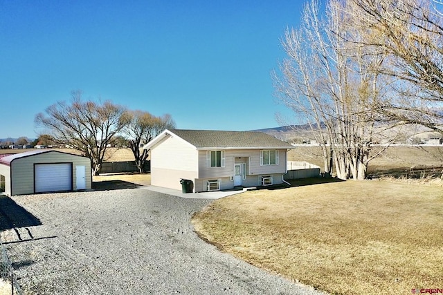 view of front of property featuring a garage, an outbuilding, and a front lawn