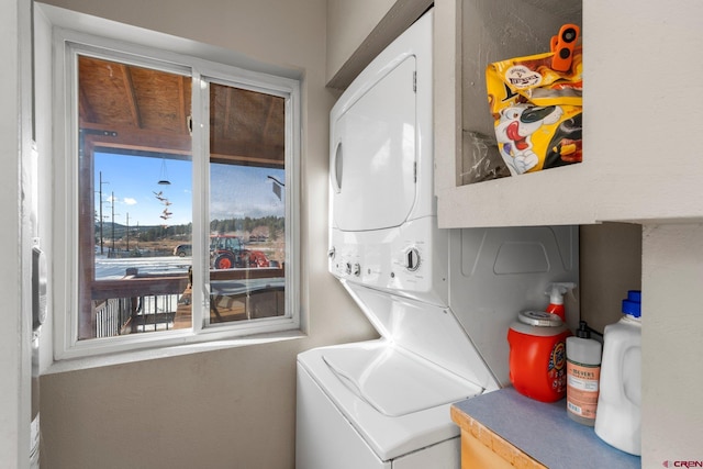 clothes washing area featuring stacked washer and dryer