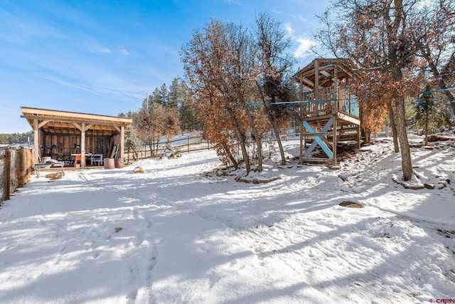 snowy yard featuring an outdoor structure