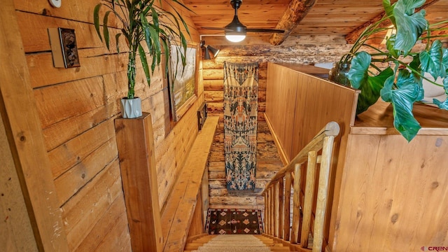 staircase featuring beam ceiling, wood ceiling, and log walls