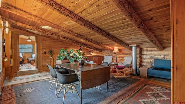 interior space featuring lofted ceiling with beams, rustic walls, ceiling fan, and wood ceiling