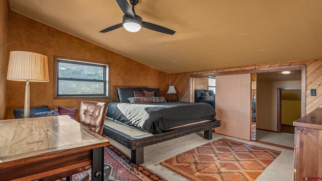 bedroom featuring wooden walls, ceiling fan, and lofted ceiling