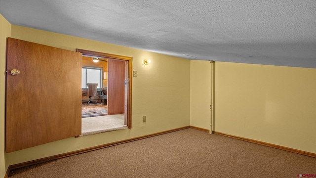 spare room featuring a textured ceiling and carpet floors